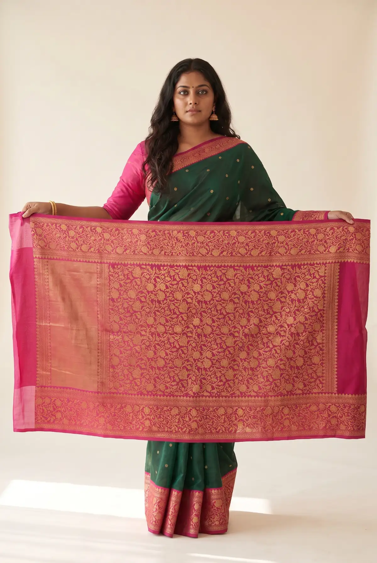 A rani pink pallu worked edge to edge in gold zari, held open